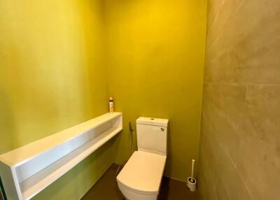 Bright yellow bathroom with modern toilet and large sink counter
