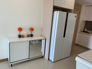 Modern kitchen corner with large refrigerator and elegant storage cabinet