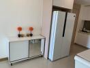 Modern kitchen corner with large refrigerator and elegant storage cabinet