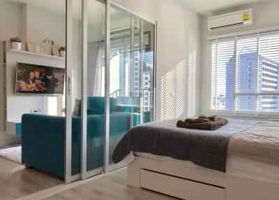 Modern bedroom with large bed, glass sliding doors, and city view