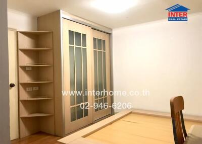 Neatly organized bedroom with built-in wardrobe and shelving unit