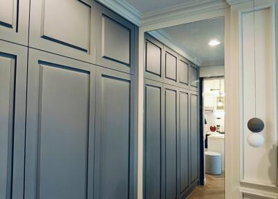 Elegant hallway with built-in storage cabinets and a view into a modern kitchen