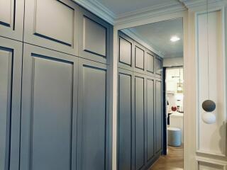 Elegant hallway with built-in storage cabinets and a view into a modern kitchen