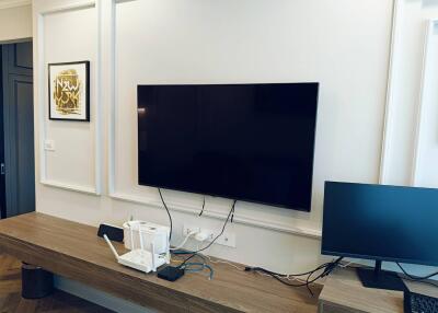 Modern living room with large television and computer setup