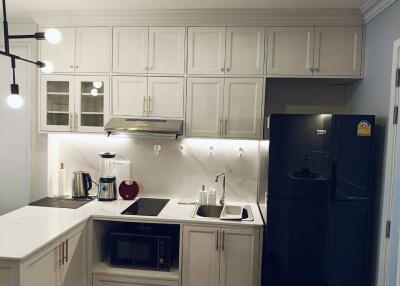 Modern kitchen with white cabinets and black appliances