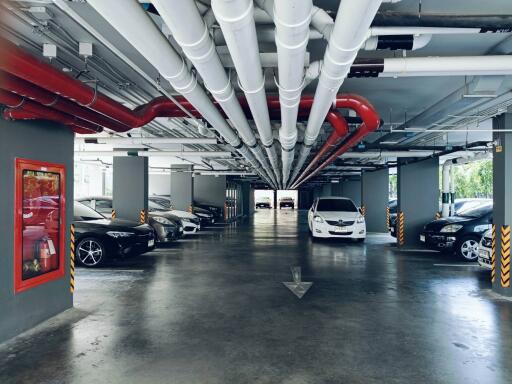 Well-organized underground parking garage with visible piping
