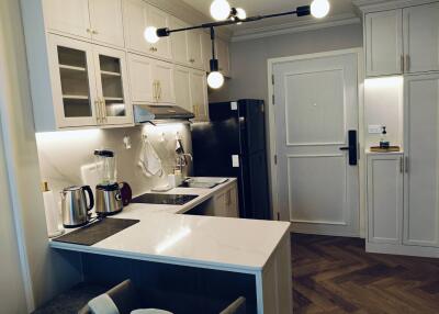 Modern spacious kitchen with white cabinetry and integrated appliances