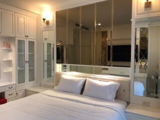 Elegant bedroom with large mirrored closets and white cabinetry