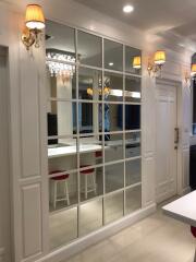 Elegant white kitchen with glass partition doors and bar seating