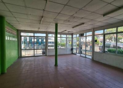 Spacious empty commercial space with large windows and green walls