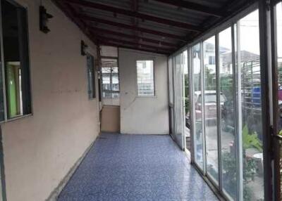Spacious covered balcony with blue tiled flooring and glass enclosures