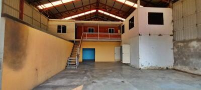 Spacious warehouse interior with upper level office space and large entry doors