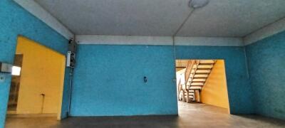 Spacious blue-painted garage with direct staircase access