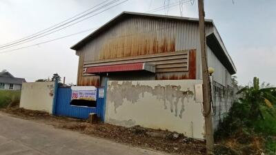 Rustic and weathered warehouse exterior with faded walls and metal roof