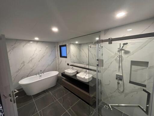 Spacious modern bathroom with double vanities and freestanding tub