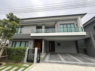 Modern two-story residential home with spacious driveway and balcony