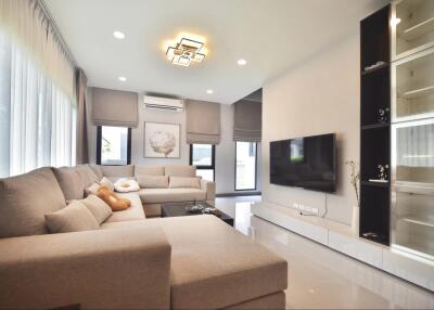 Spacious and modern living room with large sofa and flat-screen TV