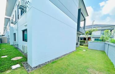 Side view of a modern house with well-maintained lawn and pathway