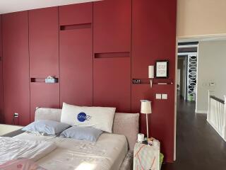 Elegant bedroom with red accent wall and modern design