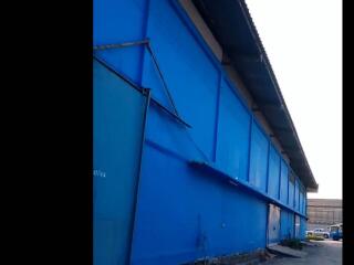 Exterior view of a blue industrial warehouse