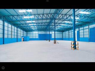 Spacious industrial warehouse interior with blue walls and bright lighting
