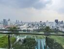 Expansive city view from a high-rise balcony overlooking a swimming pool and golf course