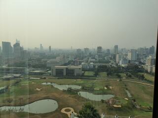 Cityscape view from a high-rise building showcasing urban landscape and a golf course