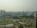 Cityscape view from a high-rise building showcasing urban landscape and a golf course