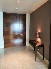 Elegant entrance hall with wooden door and decorative table lamp