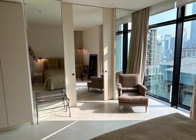 Spacious modern bedroom with expansive views of the city through floor-to-ceiling windows