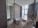 Modern spacious bathroom with freestanding tub and large window