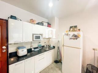Compact and well-equipped kitchen with white cabinetry and modern appliances