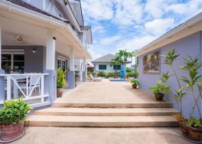 Spacious and welcoming home exterior with clear pathway and tropical plants