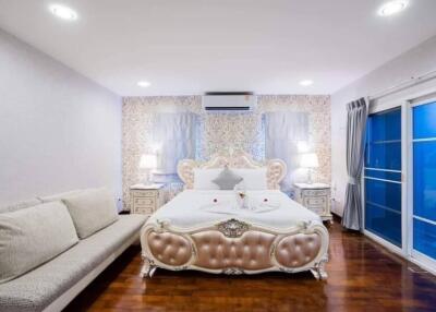 Elegant bedroom with modern and classic design elements, featuring a large bed, wooden flooring, and blue accents