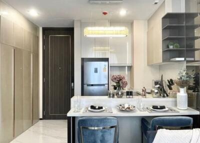 Modern kitchen with integrated dining area featuring stylish decor and lighting