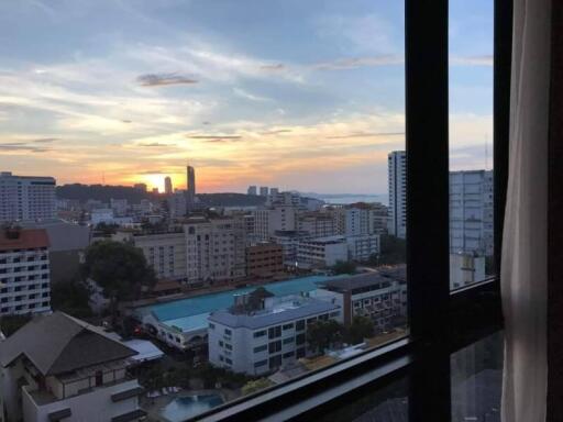 Cityscape view from apartment window at sunset