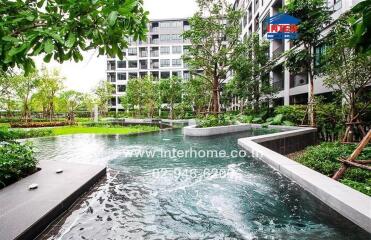 Luxurious apartment complex courtyard with a large pool and lush greenery