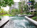 Luxurious apartment complex courtyard with a large pool and lush greenery