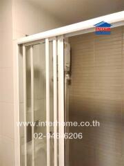 Compact bathroom with enclosed shower and mounted water heater