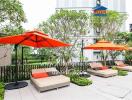 Modern outdoor lounge area with comfortable seating and vibrant orange umbrellas