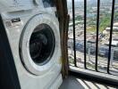 Washing machine on balcony with city view