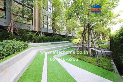 Lush garden area with walking paths in a modern residential complex