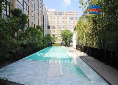 Luxurious residential building with an outdoor swimming pool surrounded by lush gardens