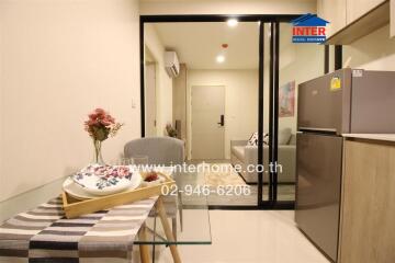 Compact modern studio apartment interior with integrated kitchen, dining, and sleeping area