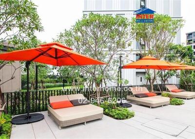 Elegant outdoor lounge with orange umbrellas and beige sunbeds