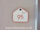 white and red number sign on a pink wall