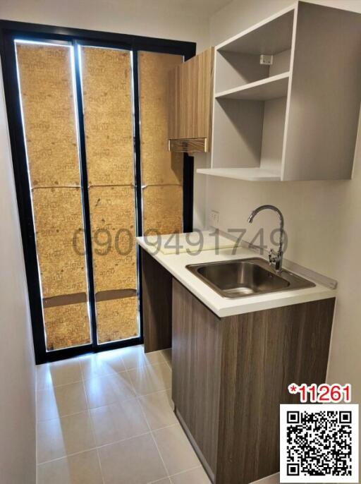 Compact modern kitchen with stainless steel sink and wooden cabinetry