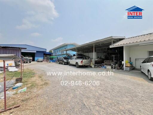 Exterior view of a warehouse with parked cars