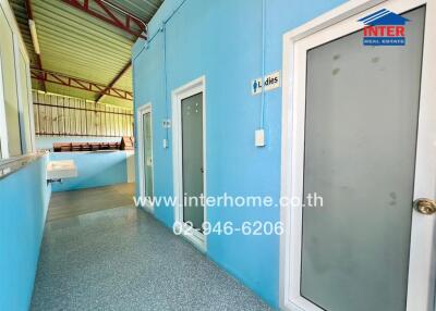 Blue corridor with doors leading to rooms and tiled flooring