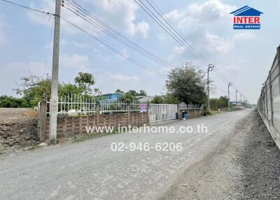 Spacious property exterior with clear skies and gated entrance
